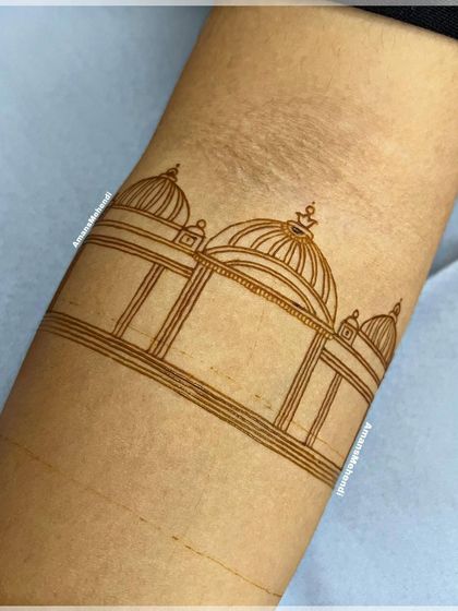 The foundational outline of a grand palace design on the forearm. This shows the basic structure before the intricate details are added.