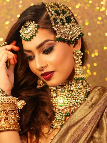 A stunning Muslim bridal look with heavy green and gold jewelry. Our students learn to create diverse looks, including the signature passa (jhoomar).