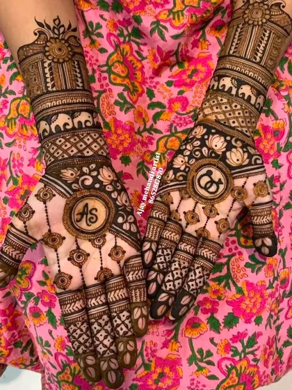 A close-up of the engagement design with 'AS' initials and interlocking rings, set against a floral dress.