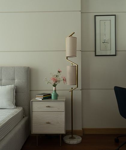 This serene bedside haven is a testament to the power of "less is more." A statement floor lamp adds sculptural intrigue, while the paneled wall creates a calming rhythm. The integrated desk makes the space functional for work as well.