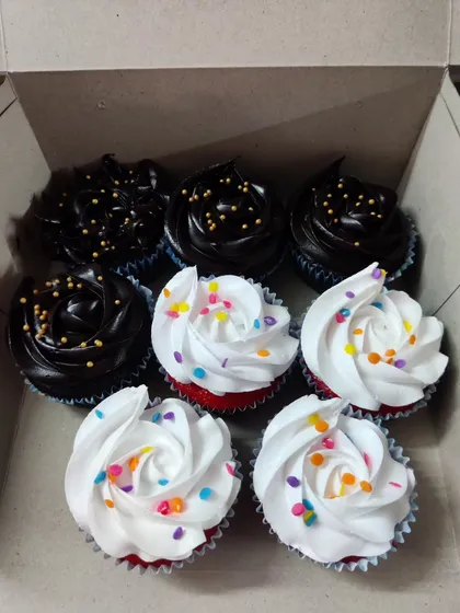 A classic combination box of my cupcakes. This one includes rich chocolate cupcakes with chocolate frosting and gold sprinkles, alongside vibrant red velvet cupcakes with white cream cheese frosting and rainbow sprinkles.
