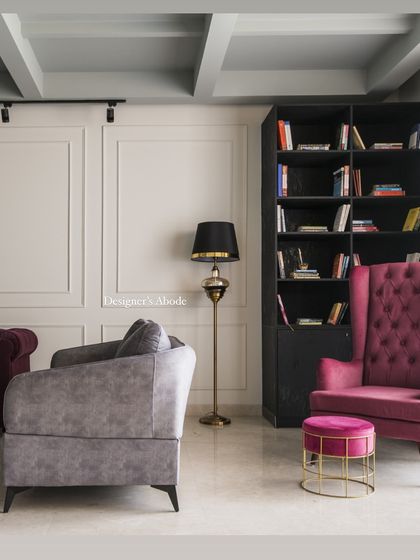 This cozy corner in a Gurgaon residence features a pink lounge chair and a curated bookshelf. It's a perfect example of how we create dreamy nooks for relaxation, blending comfort with personalized design.
