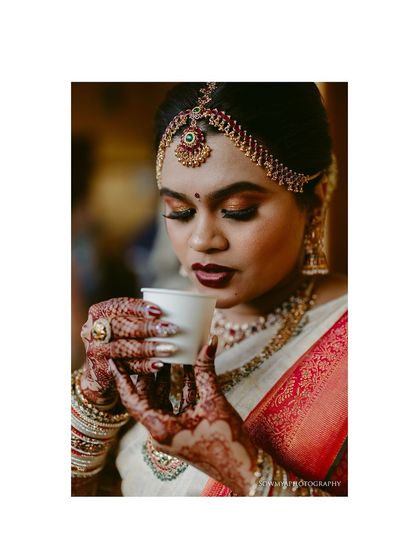 A close-up of a bride savoring her coffee. The rich colors of her makeup and the detail of her henna make this a beautiful, candid portrait.