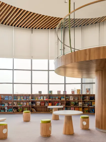 Another view of the Vedanya School library, showing the mezzanine level and child-friendly furniture. The design provides different vantage points and seating options to accommodate various activities and preferences.