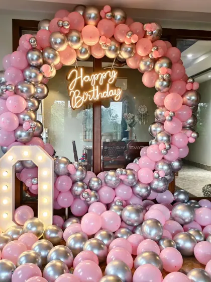 Celebrating a big milestone? I design elegant and fun decorations for adult birthdays too. This 40th birthday setup features a stunning pink and silver balloon ring, a "Happy Birthday" neon sign, and large marquee numbers, creating the perfect chic backdrop for the party.