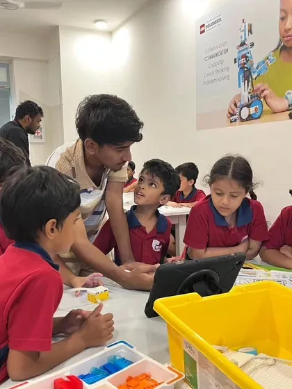An instructor guides a group of Vidyashilp Academy students through a coding exercise on a tablet. Our after-school programs are designed to be collaborative and highly engaging.