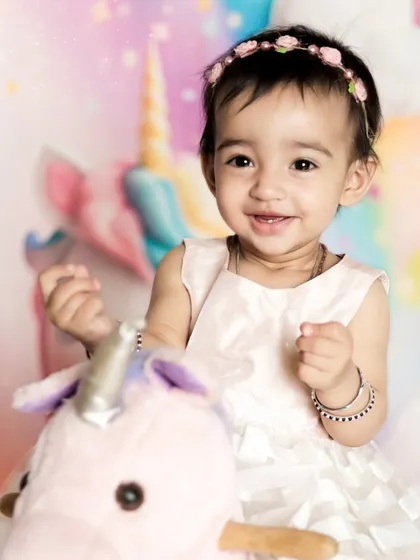 A close-up of the birthday girl with her unicorn. Her happy smile shows how much she's enjoying her special photoshoot.