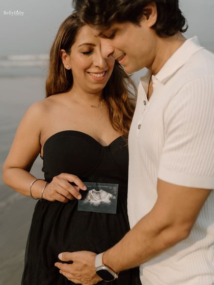 The first family photo. Holding their baby's first picture on the beach where they've shared so many memories is incredibly special.