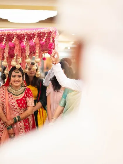 The bride's entrance under a 'phoolon ki chadar', shot from the groom's perspective.