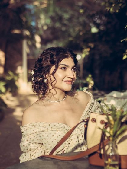 A candid, smiling portrait that captures the charming and warm atmosphere of the outdoor cafe setting.