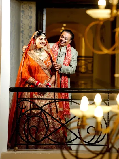 A sweet moment between the bride and her father on the balcony of the wedding venue.