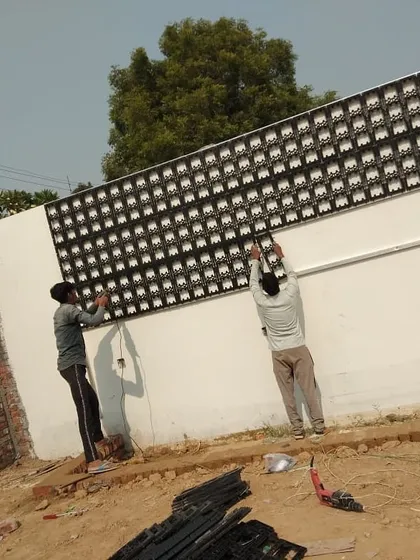 This image shows the installation of a much larger vertical garden frame on an exterior wall. You can see my team securing the extensive grid, preparing the foundation for what will become a large living wall.