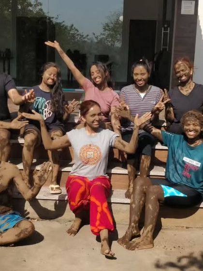 A group of our YTTC participants covered in therapeutic mud, celebrating the festival of Holi with joy and connection to the earth.