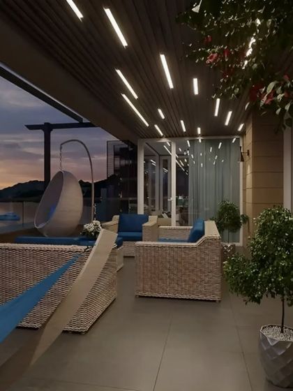 A luxurious and spacious terrace with multiple seating options, including wicker sofas, a hanging egg chair, and a hammock. The design is perfect for entertaining guests with a stunning waterfront view.