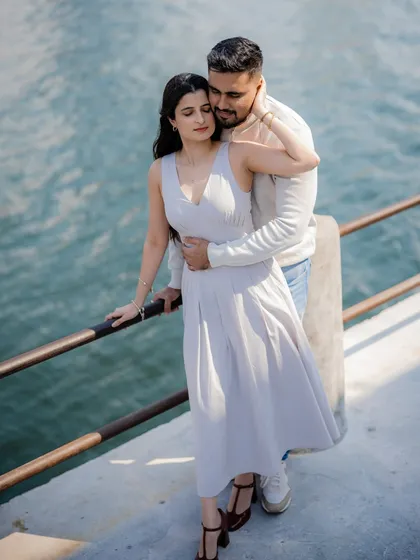 A serene pre-wedding portrait by the water in Dubai. The calm blue of the water complements the gentle embrace, creating a feeling of peace and deep affection. It’s a quiet moment that speaks volumes.