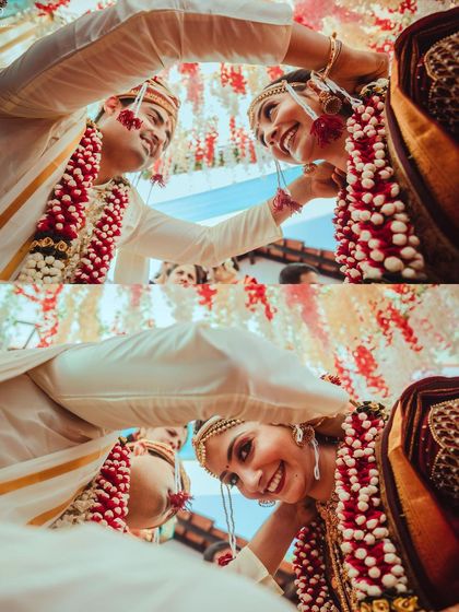 A low-angle shot capturing the joy and playfulness of the Varmala exchange.