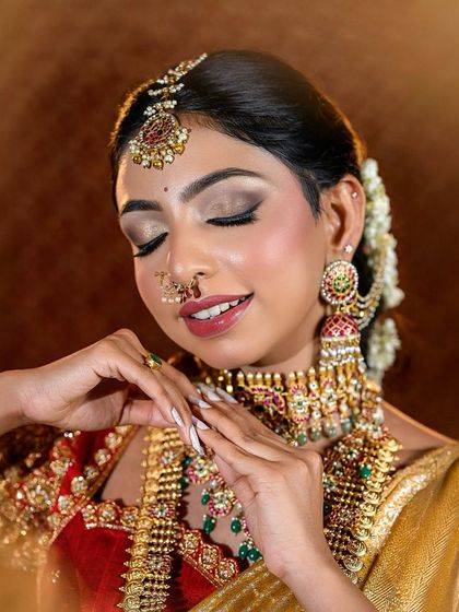 A close-up of the signature Muhurtham look, with eyes closed to showcase the beautiful gold and brown eyeshadow work.