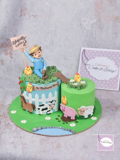 An "Old Macdonald's Farm" cake where the main farmer is a 3D topper and the animals are 2D decorations. This is a great way to reduce the amount of fondant on a cake while still having a fun, themed design.