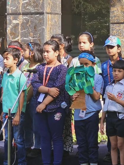 Students participate in an outdoor assembly for Earth Day, with some holding handmade props. We believe in taking learning outside the classroom to connect students more deeply with nature.