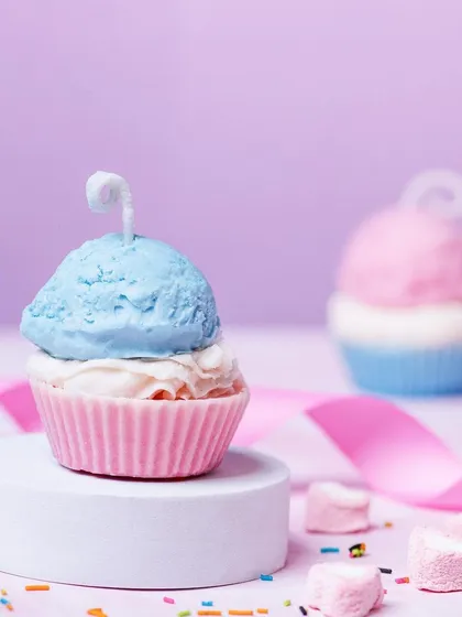 A playful shot of a cupcake-shaped candle from Delight Candles. The pastel colors and sprinkle props create a sweet, dessert-themed image.