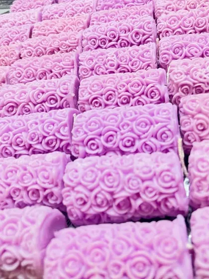 A whole tray of lavender-colored rose pillar candles, freshly made. This shows how I can prepare larger quantities for events or bulk orders.