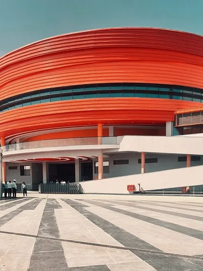 The vibrant orange facade of the MARC Auditorium at the MAHE Bengaluru Campus. This building acts as a cultural landmark within the campus, with its bold form and color creating a strong visual identity for this important community hub.