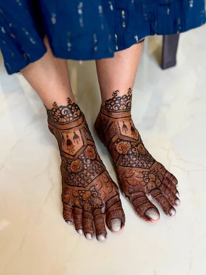 A beautiful bridal feet mehendi with intricate patterns. The design covers the feet in a classic, elegant style, perfect for a bride's special day.