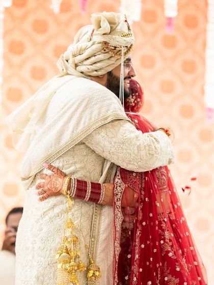 A heartfelt hug after the varmala ceremony. This photo captures the emotional connection and relief of the moment.