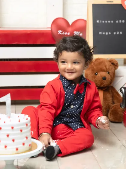 A classic pose with the birthday cake. This little one's bright smile and smart red bow tie make this Valentine's themed photo extra special.