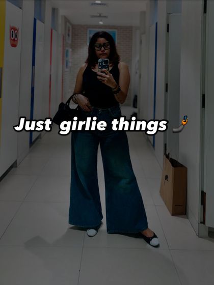 A full-length mirror selfie showing a casual Saturday outfit. A simple black tank top paired with wide-leg denim creates a chic and effortless look for a day out with a friend.