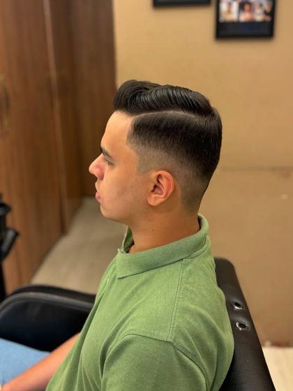 A side view of a classic men's haircut, showing the clean fade and a perfectly styled side part.