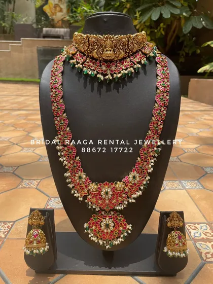 A vibrant and colourful bridal set. The long haram and choker are adorned with red and green Kemp stones, creating a festive and celebratory look.