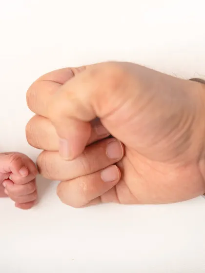 Another take on the fist bump, showing the strength and protection of a parent's hand next to the delicate fist of a newborn.