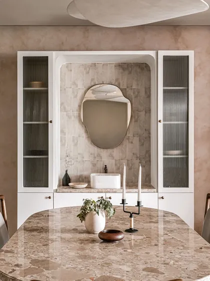 A closer look at the dining area's main feature: the built-in unit with a wash basin, organic-shaped mirror, and reeded glass cabinets. This is a perfect example of my bespoke, functional design.