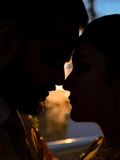 A silhouette shot that focuses purely on the connection between the couple. The last light of the day creates a powerful, intimate, and artistic frame.