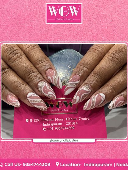 Abstract swirls of white and silver glitter on a neutral pink base give these almond-shaped extensions a dynamic and modern feel. This design is perfect for those who love unique, artistic nails.