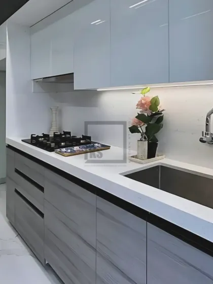 In this monochrome kitchen, we paired sleek white countertops with a built-in hob and sink for a clean, continuous workspace. The combination of handleless upper cabinets and drawers below keeps the look minimalist and modern.