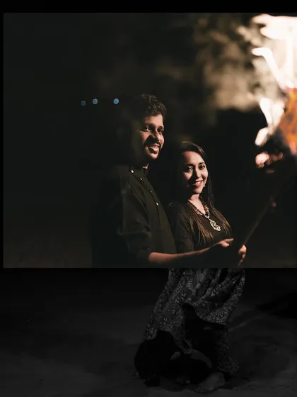 Sharing a warm moment by a bonfire at night. This is a great concept for a cozy and intimate pre-wedding session.