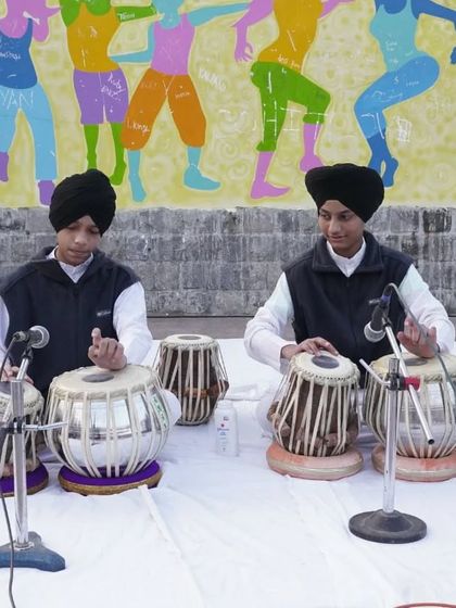 A focused shot of our students during a tabla duet performance at an outdoor event.