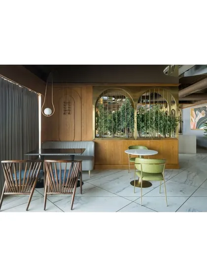 The dining area at Citadines is designed for fluid transitions, with a mix of seating types to accommodate everything from a quick coffee to a leisurely dinner. Slender brass arches frame planters, subtly defining zones without rigid separations.