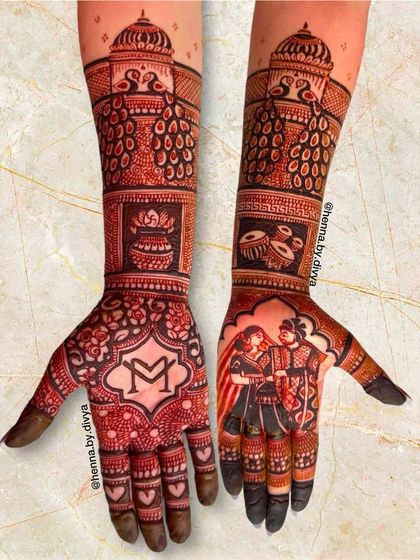 This full bridal mehendi features a couple portrait on one palm and the initial 'M' on the other. The arms are adorned with peacocks, dhol, and kalash motifs.