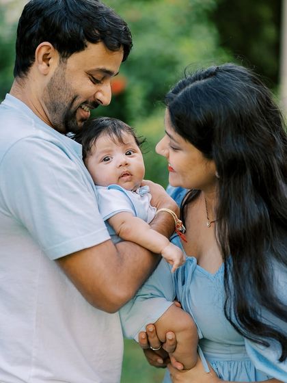 A family in matching blue outfits with their new baby. Coordinating colors can create a beautiful and cohesive family portrait.