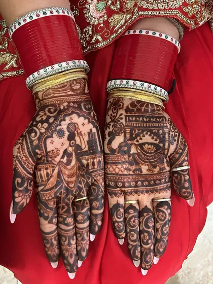 A traditional Karwa Chauth story on the palms. This design shows a woman carrying a pot on her head and a scene of a couple, capturing the essence of the festival.