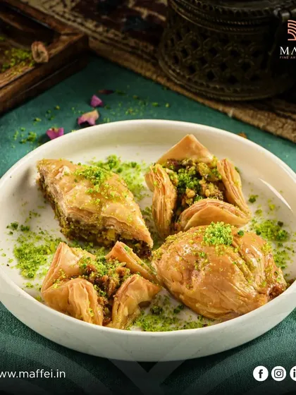 An assortment of our hand-crafted baklava. The different shapes and fillings showcase the variety and artistry of this beloved Mediterranean dessert.