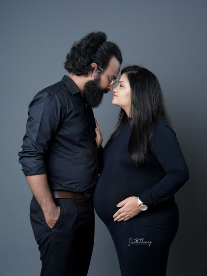 A classic and intimate couple portrait against a solid grey background. Their close embrace and loving gaze create a powerful and timeless image of their bond.