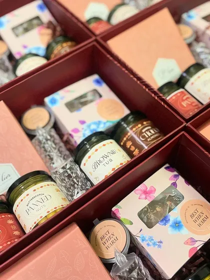 An inside look at our large Diwali hampers being assembled, showing the careful arrangement of dessert jars, brownie tubs, and other sweet treats.