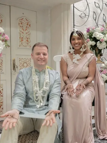 The bride and groom together, both with small henna designs, sharing a special moment.