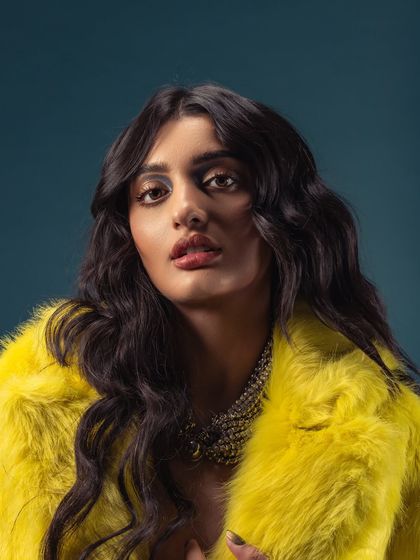 A direct, confident portrait in the yellow fur coat. This look is all about being bold and unapologetic, which is a core part of my identity as an artist.