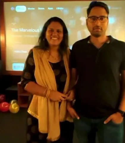 A happy couple enjoying their private screening. You can see our user-friendly interface on the screen behind them, where you can easily log into Netflix, Prime, Hotstar, and more.
