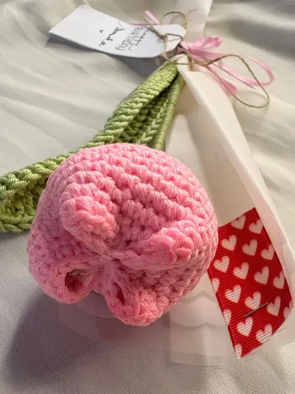 A detailed shot of the pink crochet tulip head. You can really see the texture of the stitches that form the beautiful petal shapes.